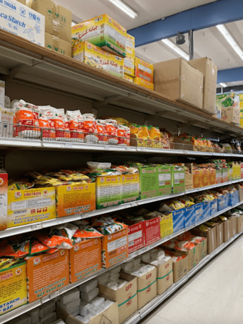 A grocery store aisle filled with colorful packages of various food products and ingredients on shelves.